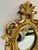Charming vintage oval wall mirror in the Rococo or Italian Florentine tradition, with an ornate gilt wood frame featuring...