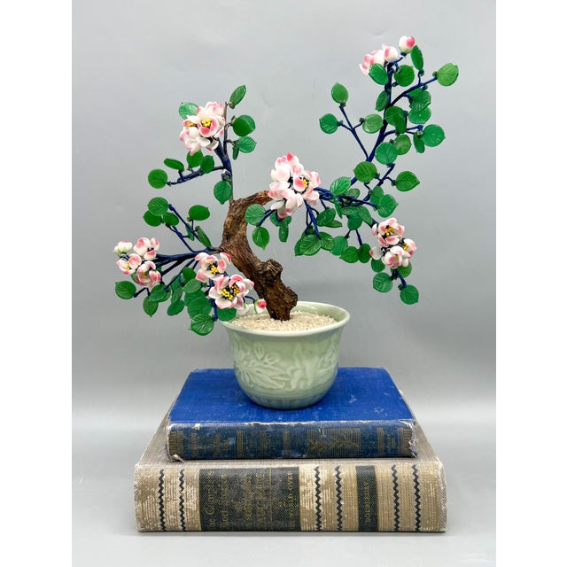 Magnificent bonsai tree inside a stunning celadon pot. Features delicate pink and white petals that make up cherry...