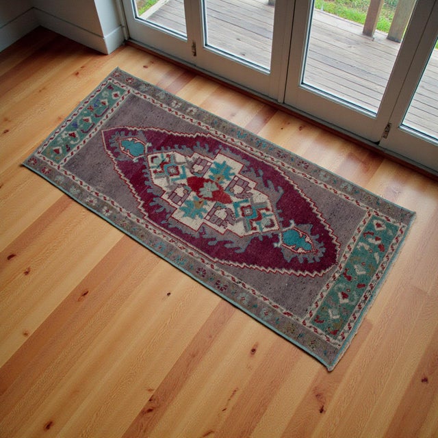 This vintage Oushak mat brings a sophisticated splash of Aegean color to your floor, featuring a beautifully sun-faded...