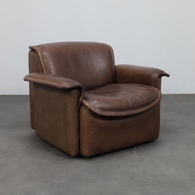 A beautifully aged ds-12 lounge chair produced by de sede in switzerland during the 1970s. Upholstered in rich brown neck...