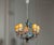 This stunning Italian chandelier from the 1950s features an intricately designed metal frame with hand-painted polychrome...