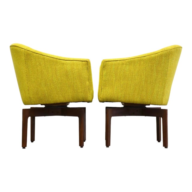 A pair of mid century modern lounge chairs with cross base legs and 90 degree return swivels designed by Jens Risom. Newly...