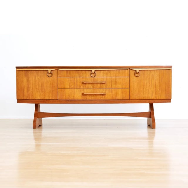 This vintage mid-century credenza was designed and manufactured by Beautility Furniture in England during the 1960s. This...