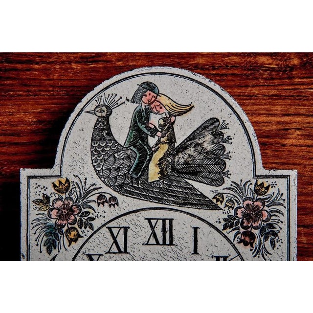 This charming ceramic wall clock features a whimsical, hand-illustrated scene in a distinctly mid-century French folk-art...