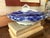 A beautiful antique English flow blue covered tureen featuring richly saturated cobalt blue floral scrollwork that softly...