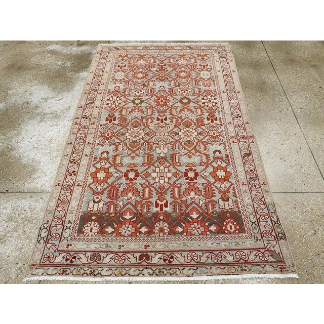 This mid-20th-century Persian Malayer accent rug presents a lively allover floral composition across a soft blue field....