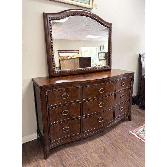 This transitional dresser features a gently bowed front, richly patterned burled-finish drawer fronts, and nine spacious...