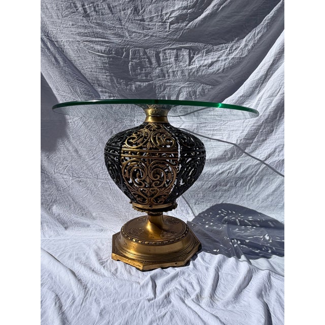 Striking vintage Hollywood Regency pedestal table featuring an ornate gilt metal orb base with dramatic scrollwork...