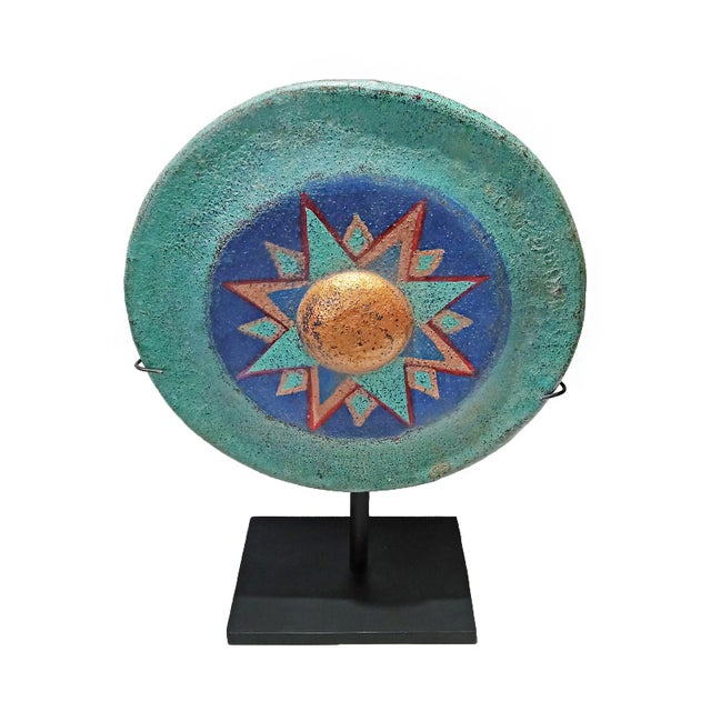 A vintage Indonesian gong, polychromed and repurposed as a freestanding sculpture. Mounted on a black metal stand. Circa...