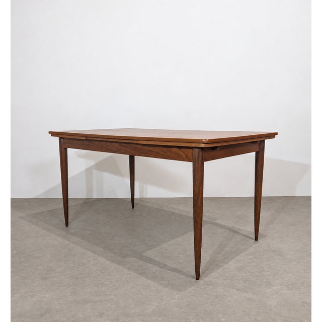 Vintage Scandinavian extendable dining table in teak with a rectangular top, rounded corners and tapered legs. The table...
