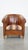 This characterful, vintage cognac-colored club chair made of sheep leather with a colorful fabric seat cushion. This great...