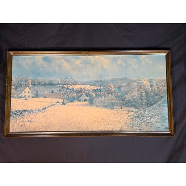 A large framed winter countryside landscape wall art piece featuring a peaceful rural scene with a farmhouse, barn, trees,...