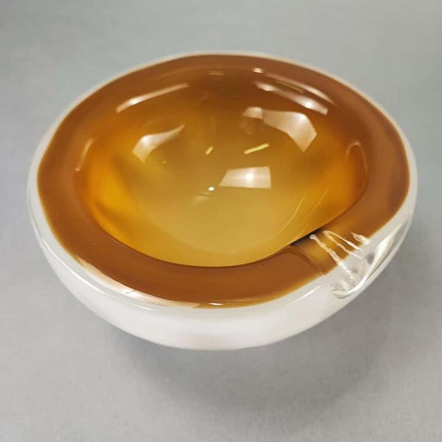 A 1970s bowl-shaped ashtray in white and brown Murano submerged glass with a finish on the outer rim. Perfect vintage...