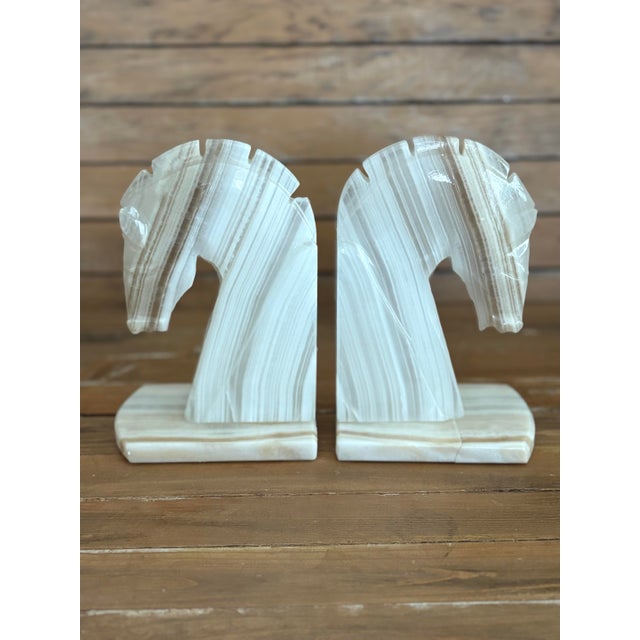 Bring sculptural elegance to your shelves with this vintage pair of carved onyx horse head bookends, crafted from...