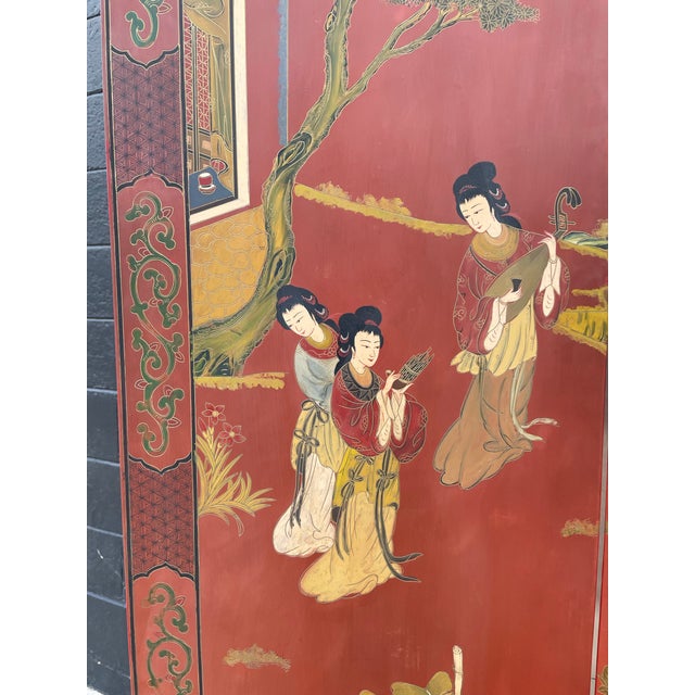 An exquisite antique Chinese four-panel screen, richly finished in a deep oxblood red lacquer, showcasing exceptional...