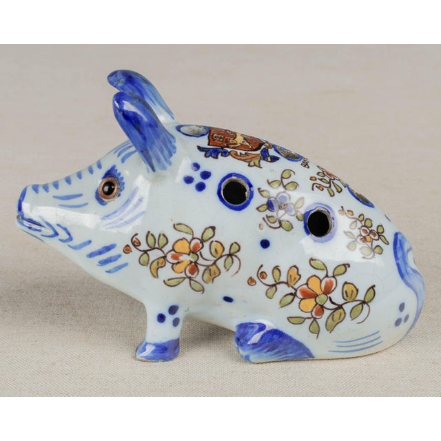 A French faience whimsical pique-fleur bud vase in the form of a seated pig. Hand-painted with floral motif in typical...