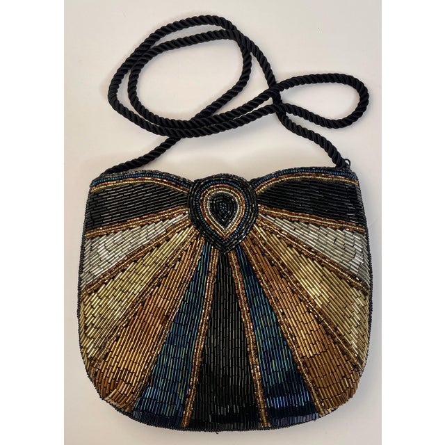 Beautiful evening bag with a sunburst pattern of iridescent beads in silver, gold, bronze, teal, and black with a zipper...