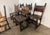 A striking set of six Spanish Revival armchairs crafted from richly patinated hardwood and fitted with hand-tooled leather...
