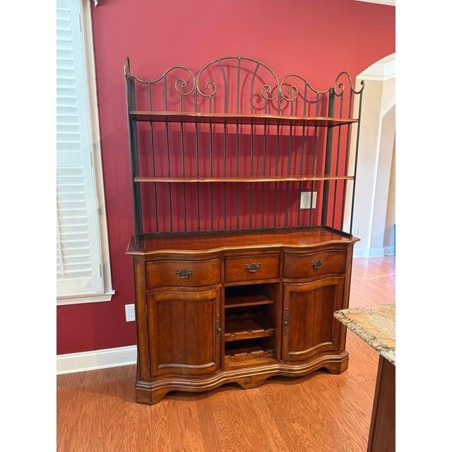 Lovely French style sideboard server or buffet with attached bakers rack. This piece made by Universal features a scrolled...