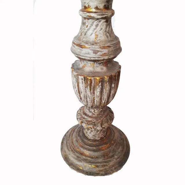 Tall, hand-carved wood candlestick from India. Gilt finish, distressed. Holds candles up to 4 inches in diameter.