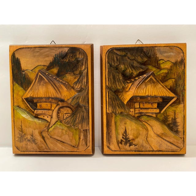 Pair of beautiful wooden hand carved German Black Forest cottage and landscapes with some areas being hand painted in green.