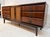 Elegant mid-century modern dresser featuring a rich walnut-toned finish, nine drawers, and a central two-door cabinet with...