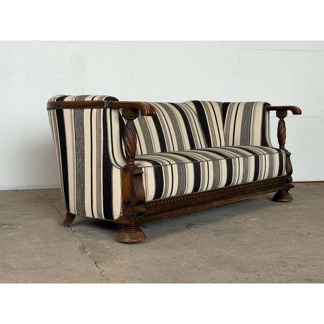This sofa is built in solid oak in the Renaissance Revival style, likely produced in Denmark in the early 20th century....