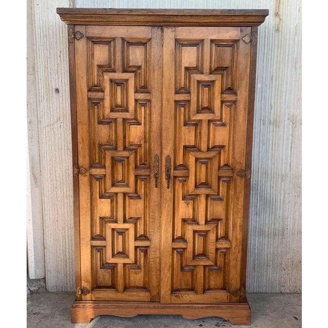 Armoire, cupboard or kitchen cabinet with two doors decorated to the outside with geometric patterns framed by moldings....