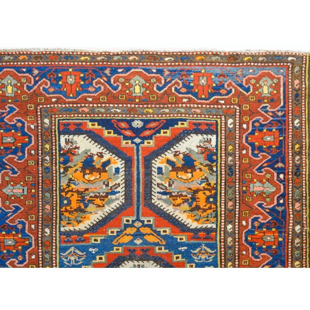 A wonderful early 20th century Persian Bakhtiari rug with an unusual floral partnered field woven in crimson, orange,...