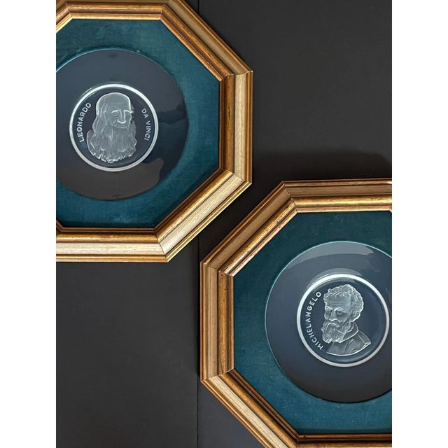 Set in teal velvet and presented in antique gold wood octagonal frames, this pair of etched intaglios in glass of...