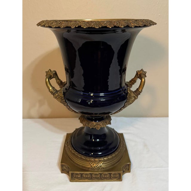 United Wilson cobalt glazed porcelain large urn vase with gilt bronze mounts. The platform base and the urn are two...