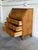 A slant drop-front writing surface opens to reveal internal small drawers and compartments over three deep lower drawers....