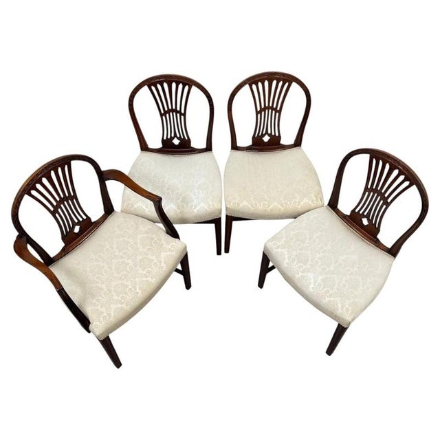 An elegant and finely crafted set of eight 19th-century English dining chairs in the Hepplewhite style, comprising six...