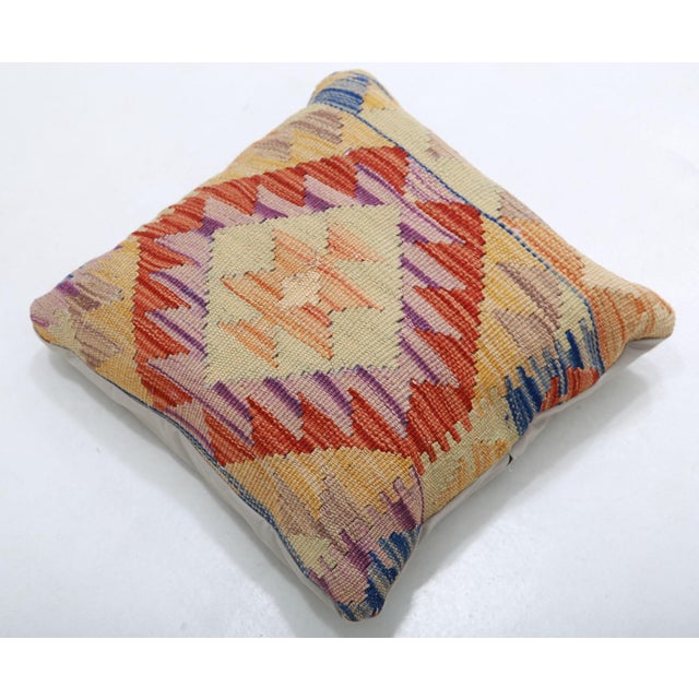 A one-of-a-kind handwoven Afghan wool kilim accent pillow featuring coral diamond medallion on cream. Cut and sewn by hand...