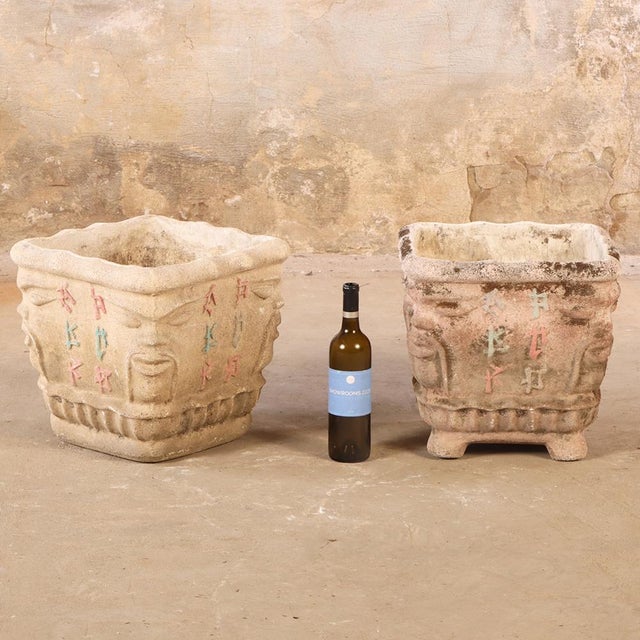 This pair of cast stone planters features distinctive face motifs at each corner, giving them a playful, architectural...