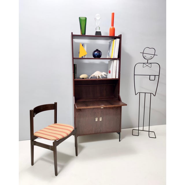 Made in Italy, 1950s - 1960s. This bookshelf and secretaire features a walnut frame with nickel-plated brass handles and...
