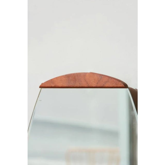 Magnificent oval beveled mirror with 2 teak parts at the top and bottom a model dating from the 1960s. beveled edge on the...