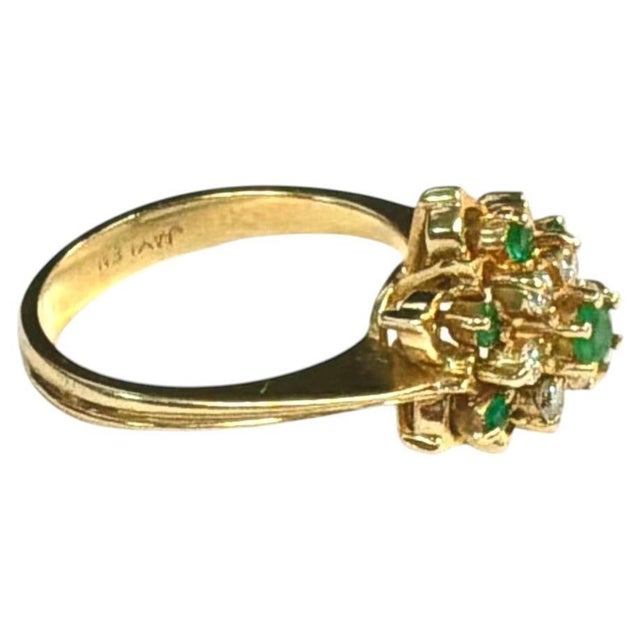 Vintage 14K Gold Emerald and Diamond Floral Cluster Cocktail Ring, circa 1960s-1970s. Ring features seven small round...