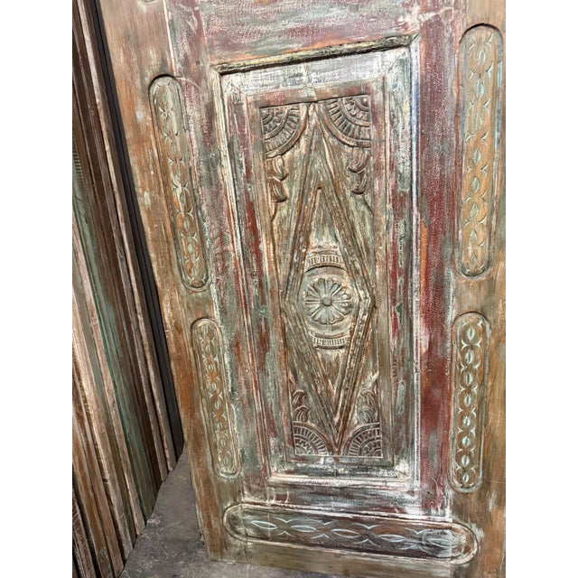 A striking blend of Old World craftsmanship and rustic-modern appeal, this antique carved door is a true statement piece...