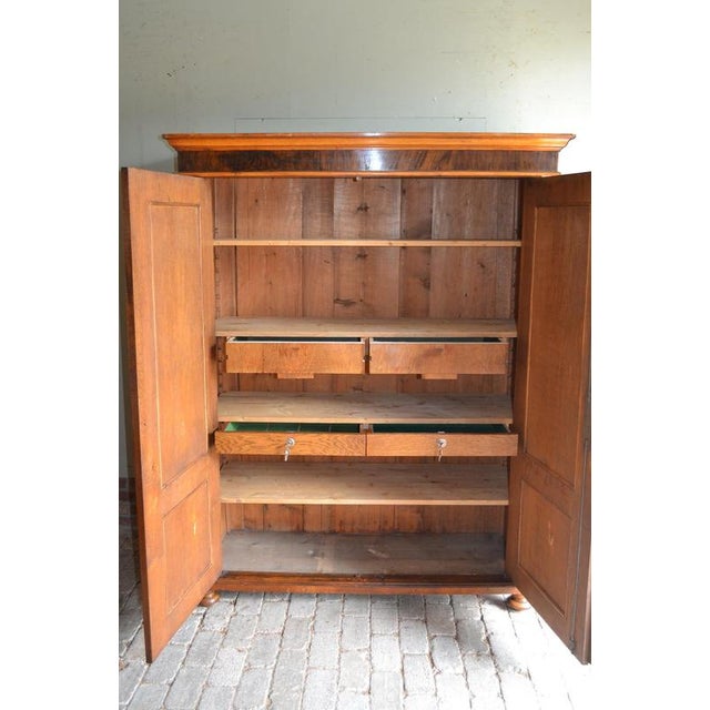 of a 19th-century German mahogany and walnut cabinet. The height is 175 cm. The width is 135 cm. The depth is 58 cm....