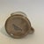 Crackle glaze, tan color with a teal stripe along the top of the Creamer or Syrup Pitcher. Marked at bottom, "Statastone...