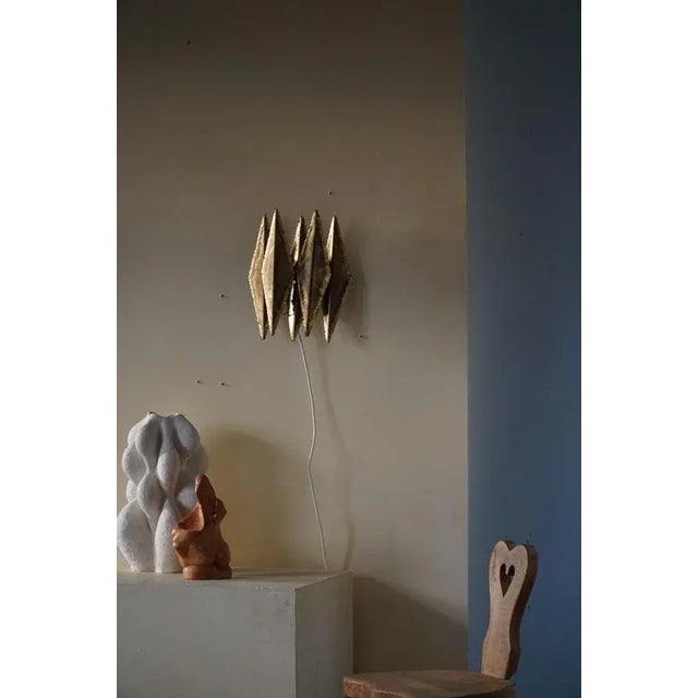 Danish modern brutalist wall unit light, made by Svend Aage Holm Sørensen in 1960s. The brass petals are torch cut and...