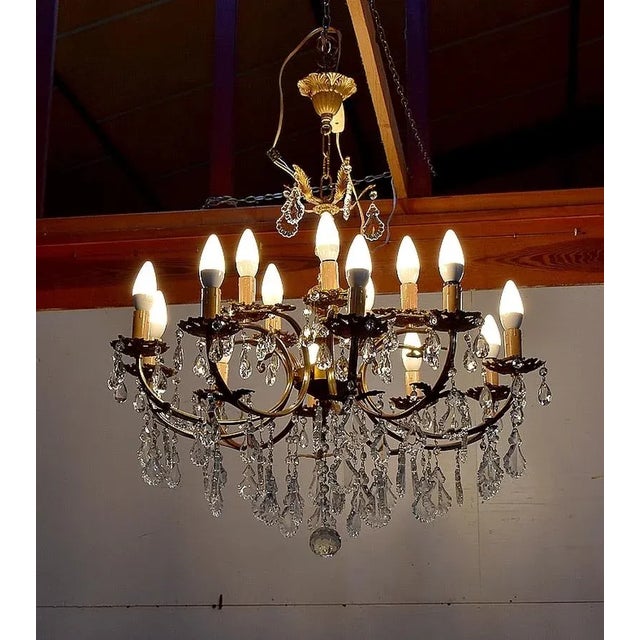 Elegant chandelier with structure in bronze and brass, ended with bohemian crystals. it consists of ten arms brass,...