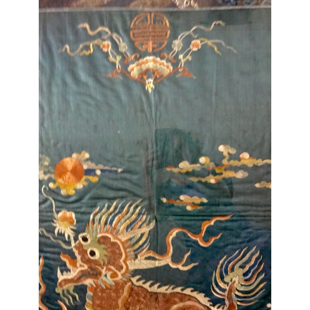 Qing dynasty embroidered silk tapestry with the mythical qilin creature. It is embroidered in gold. The symbol on top is...