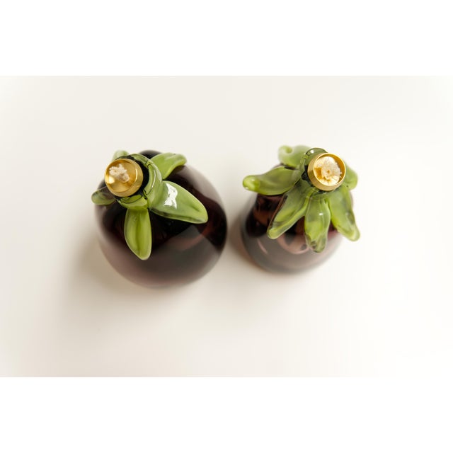 A pair of handcrafted art glass oil lamps in a distinctive eggplant shape, signed on the bottom by artist Lewis Haynes....