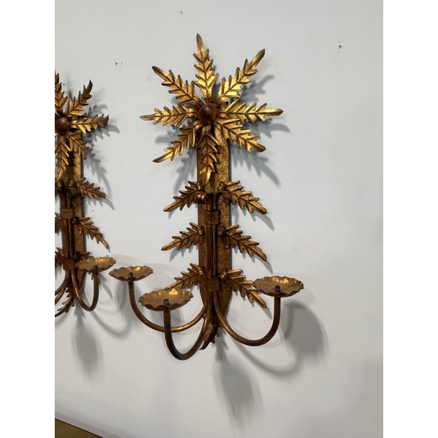 Note: We are able to wire these if requested for a small fee. This matched pair of three-light wall sconces presents a...
