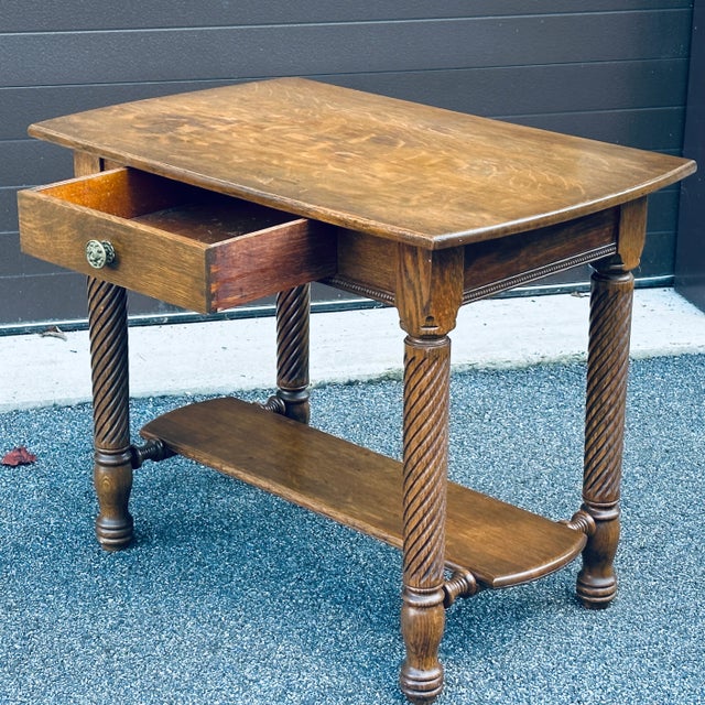 Antique quartersawn solid oak library table with spiral twist carved legs and single drawer.