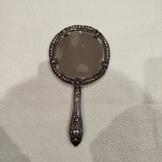 Silver Hand Mirror. 98 grams. Height: 7.09 in (18 cm) Width: 3.55 in (9 cm) Depth: 0.4 in (1 cm) This piece has an...