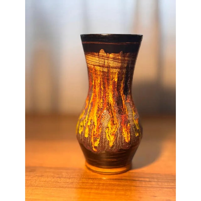 A 1970s ceramic vase by Saint-Clément, distinguished by its flared neck, pinched waist, and richly textured lava glaze in...