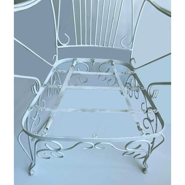 Pair of antique French white painted wrought iron armchairs. Yellow, green and blue striped cushions. Please note:One...